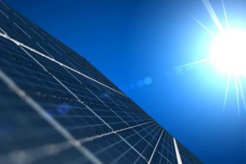 bilde viser et solcellepanel med sol på blå himmel