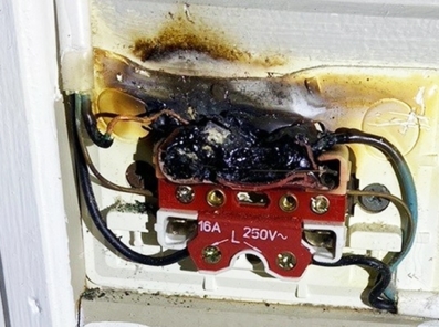 Varmgang i stikkontakt på vegg der branntilløp er neste fase