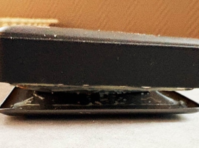 Bilde viser en sprukken powerbank med oppsvulmet batteri