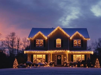 To etasjes hus med julebelysning og vakker himmel i bakgrunn